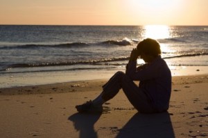 Image credit: <a href='http://www.123rf.com/photo_5902698_mature-woman-sits-on-the-beach-with-her-head-bowed-and-praying-as-the-sun-sets-on-the-water.html'>sframe / 123RF Stock Photo</a>