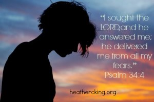 Female with head bowed in front of sunset sky